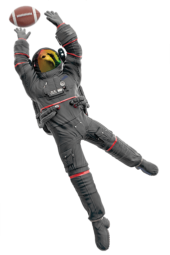 Billie Atoms dressed in a black spacesuit jumping in the air to catch a football